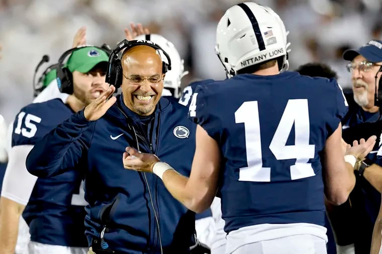 Penn State head coach James Franklin celebrating with quarterback Sean Clifford (14) after a touchdown against Michigan.