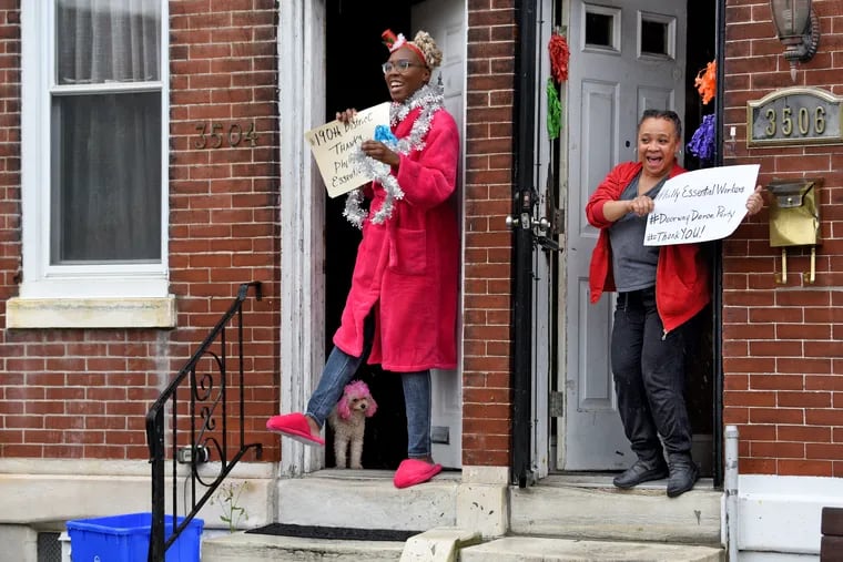 Shelia Simmons (right) and her neighbors including Onisha Claire (with dog Lucy behind the slippers) step out May 6, 2020, during the Philadelphia citywide Doorway Dance Party for essential workers she is organizing. The 6:30 p.m. nightly event — coordinated by many of the same media professionals, artists, and entrepreneurs behind the city’s Guinness World Record Largest Soul Train Line in 2012 — got Radio One/Urban One, which owns four stations in the Philly area, to play the "Rocky" theme and "Ain't No Stopping Us Now” songs back-to-back every night at 6:30 p.m.