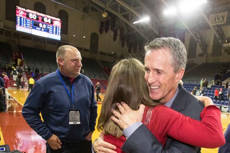 Head Coach Steve Donahue, right, of Penn is hugged by Athletic Director M. Grace Calhounafter Penn's 80-64 victory over La Salle i at the Palestra in the Big 5 game on Nov. 25, 2015.  ( CHARLES FOX / Staff Photographer )