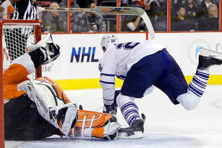 Flyers goalie Michael Leighton loses his stick after being crashed into by Toronto's Colton Orr during first period.