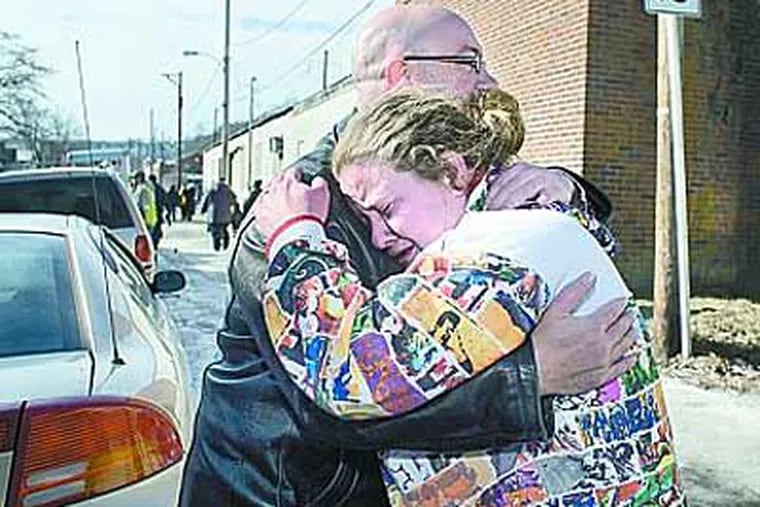 Coatesville neighbors John Wenger and Brandy Hickman embrace near their homes, which were destroyed by a suspected arson fire. (Ed Hille / Staff Photographer)