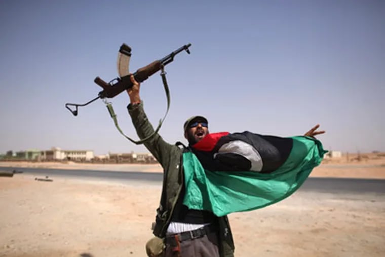 A Libyan fighter celebrates in Bani Walid, Libya, Friday, Sept. 16, 2011.. (AP Photo/Alexandre Meneghini)