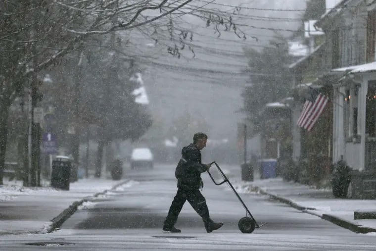 A delivery man makes his way through wintry weather in Mt. Holly, N.J., on a snowy day last year.
