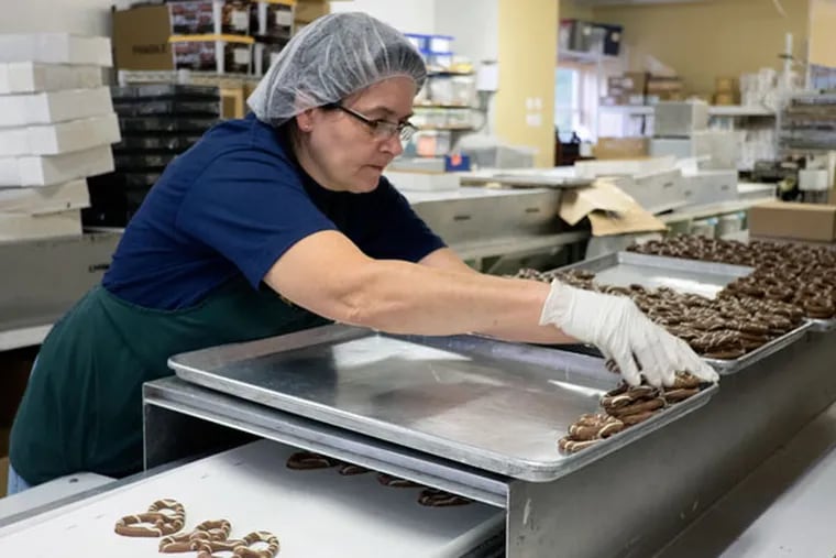 Andrea Burns readies chocolate pretzels for packaging at Giambri's in Clementon. ( ED HILLE /Staff Photographer )