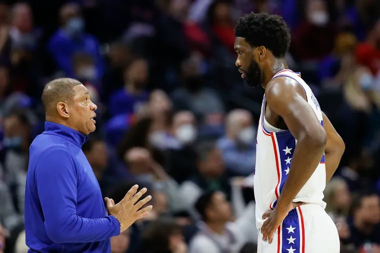 Sixers head coach Doc Rivers talks to center Joel Embiid during a game against the Cleveland Cavaliers.
