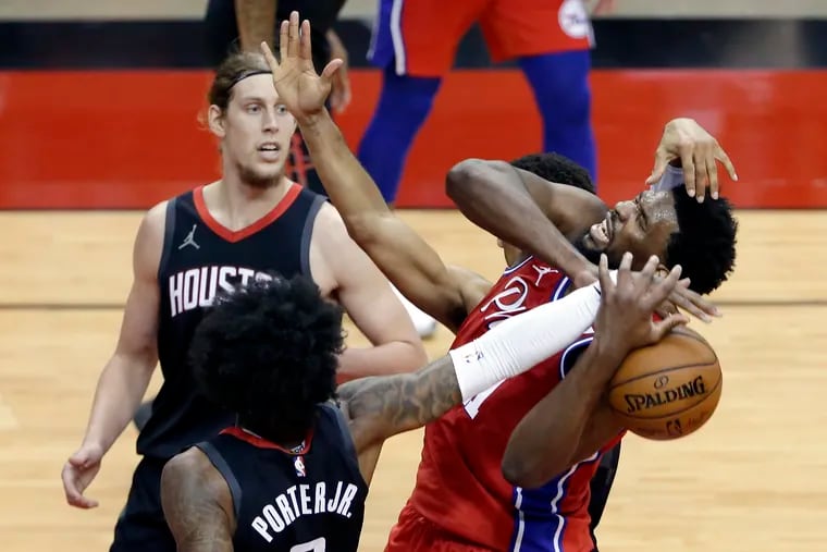 The Sixers' Joel Embiid has the ball knocked away by the Rockets' Kevin Porter Jr., left front, as forward Kelly Olynyk, left back, watches during the first half.