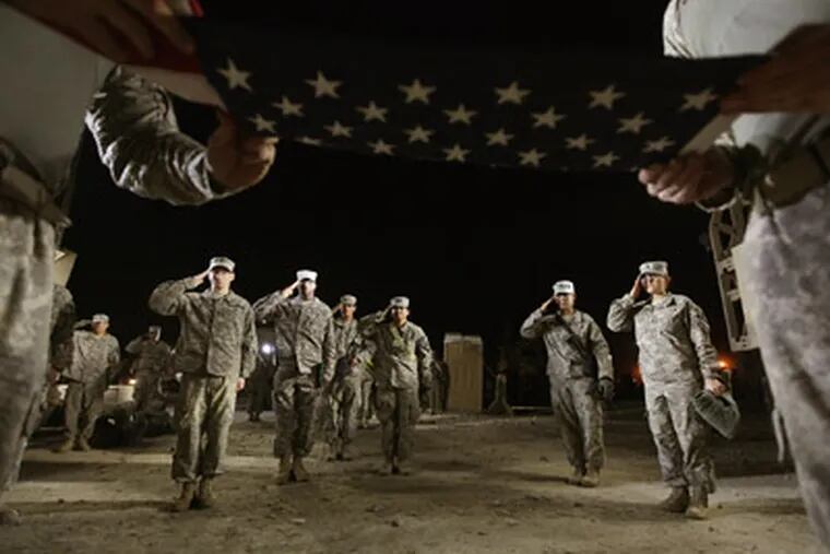 Soldiers from the 3rd Brigade, 1st Cavalry Division salute during a re-enlistment ceremony for Staff Sergeant Brant Smith, from Dothan, Alabama, while preparing to depart in the last convoy from Iraq at Camp Adder, now known as Imam Ali Base, on Saturday Dec. 17, 2011, near Nasiriyah, Iraq. Smith re-enlisted for three years of service at the ceremony which he wanted to hold at the staging area for the last convoy.  Around 500 troops from the 3rd Brigade, 1st Cavalry Division ended their presence at Camp Adder, the last remaining American base, and departed in the final American military convoy out of Iraq, arriving into Kuwait in the early morning hours of December 18, 2011.  (AP Photo / Mario Tama)