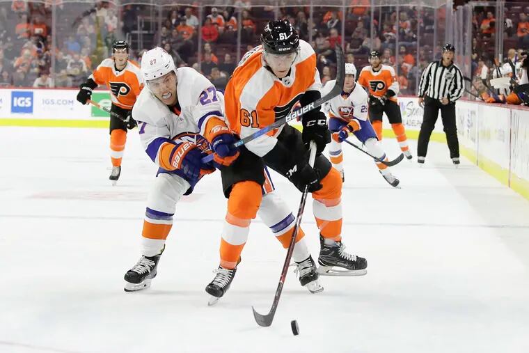 Flyers defenseman Phil Myers goes after the puck against Islanders left winger Anders Lee during a preseason game.