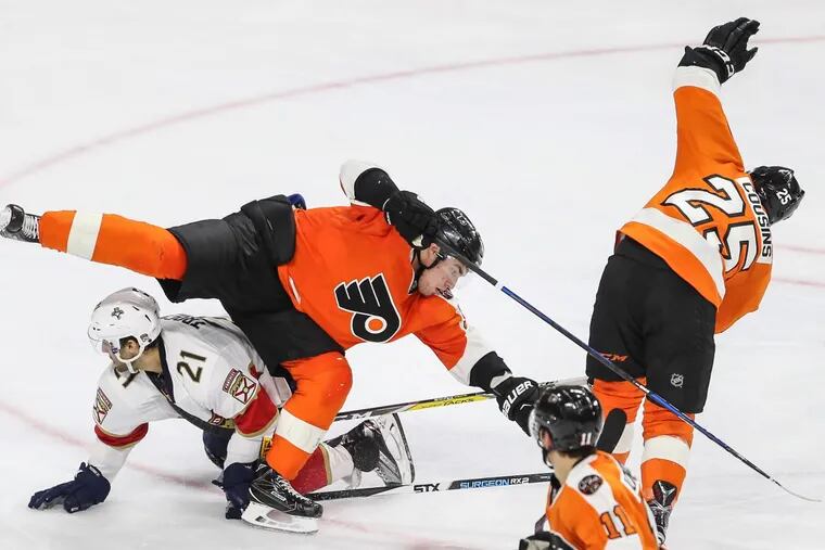 The Flyers' Nick Cousins (25) hooks Panthers' Vincent Trocheck and trips up teammate Ivan Provorov during the second period of a December 2016 game.