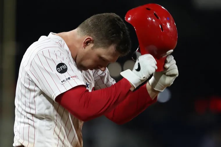 Rhys Hoskins of the Phillies slams his batting helmet on the turf after making the final out of the 8th inning against the Braves.
