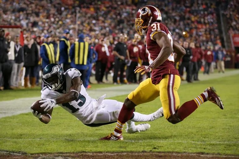 Eagles wide receiver Nelson Agholor (13) dives past Washington Redskins cornerback Fabian Moreau (31) for a touchdown in the third quarter of a game at FedEx Field in Landover, Md., on Sunday, Dec. 30, 2018. The Eagles won 24-0.