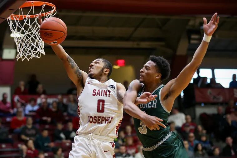 St. Joseph's Lamarr Kimble (0) attempts a layup against Wagner's Jonathan Norfleet (3) during a game at Hagan Arena in Philadelphia on Saturday, Dec. 29, 2018.
