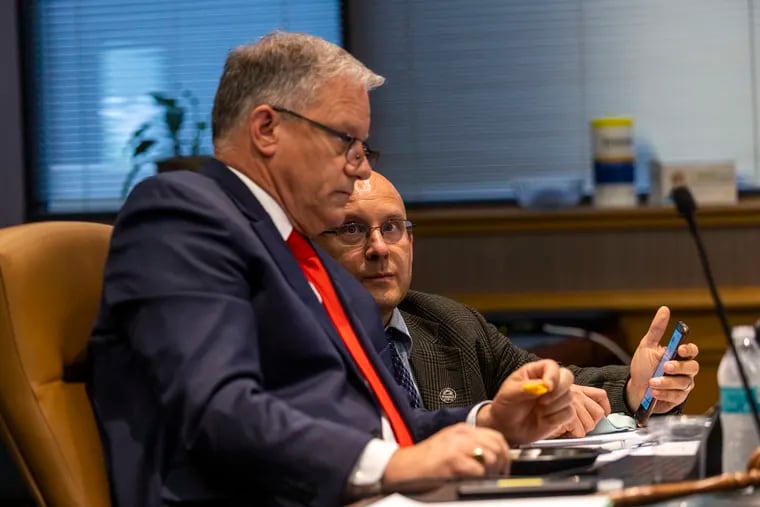 Christopher Santa Maria, board chairman, (left), and Jason Davis, chairman of the Investment Committee, converse in the PSERS boardroom at the PSERS offices in Harrisburg in June.