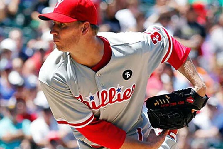 Roy Halladay allowed four earned runs on eight hits and struck out seven against the Rockies on Wednesday. (Ed Andrieski/AP)