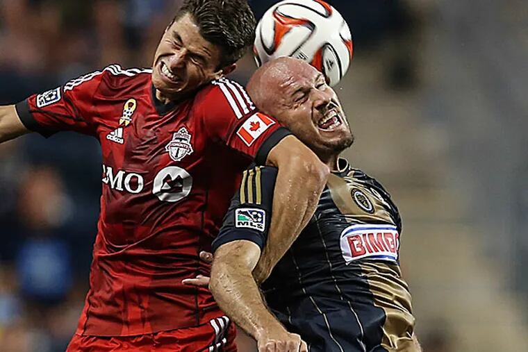 The Union's Conor Casey battles with Toronto FC's Mark Bloom during the first half. (Steven M. Falk/Staff Photographer)