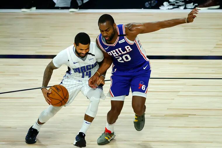 Orlando Magic's D.J. Augustin (14) is defended by Philadelphia 76ers' Alec Burks (20) during the fourth quarter of an NBA basketball game Friday, Aug. 7, 2020, in Lake Buena Vista, Fla.