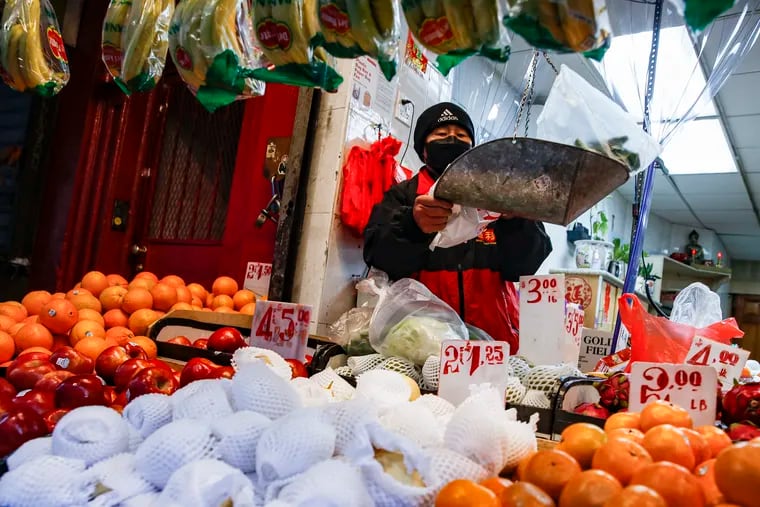 A produce worker handles food with gloves while wearing a face mask last week in New York City.