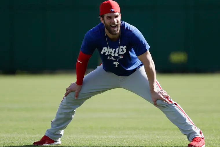 Bryce Harper has a laugh while stretching at Phillies practice on Sunday.
