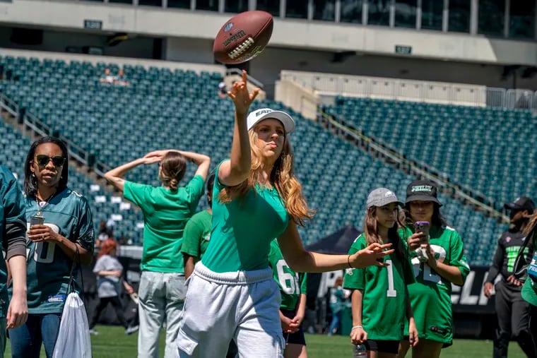 Sadie Doyle, 16, from Flemington, N.J., tosses a football on the field at the Linc during the Eagles' Women’s Football Festival on Sunday. She was there with her sister, Piper, 17.