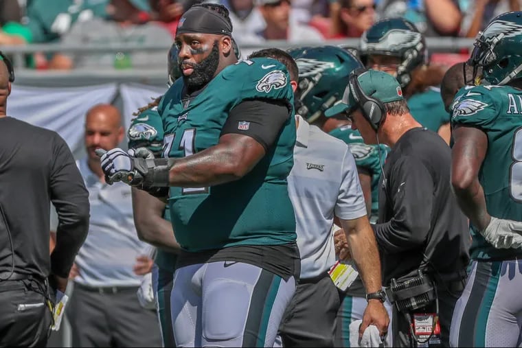 An injured Jason Peters, left, uses hand signs to coach his sub, Halapoulivaati Vaitai, from the sidelines in the third quarter of the game against Tampa Bay on Sunday September 16, 2018. MICHAEL BRYANT / Staff Photographer
