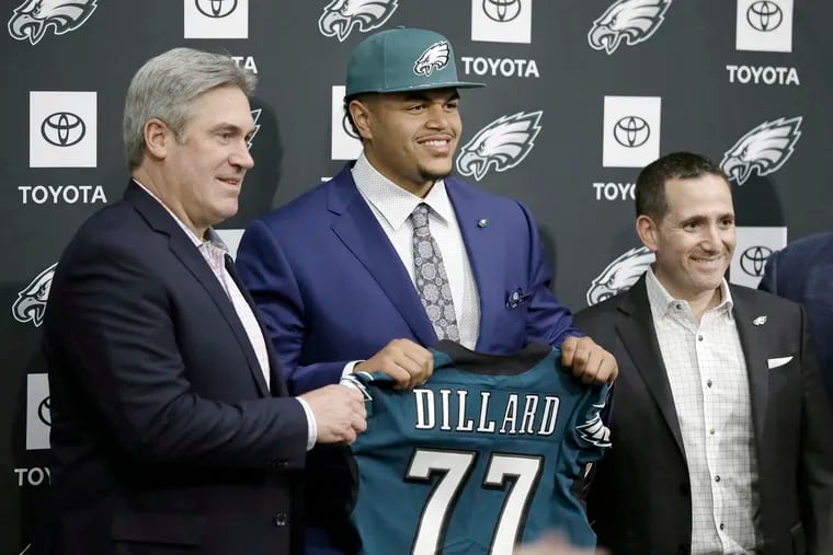 Phila. Eagles Coach Doug Pederson (left) and Eagles Exec. Vice President Howie Roseman (right) stand by  Eagles first round draft pick Andre Dillard as he displays his new # 77 Eagles jersey during a press conference at the Eagles NovaCare Complex in South Phila. on April 26, 2019.