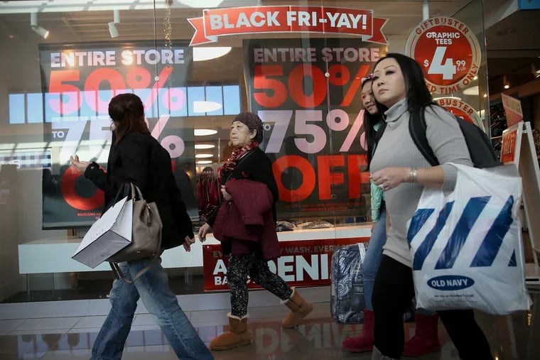 Shoppers walk past a Black Friday advertisement at Cherry Hill Mall in Cherry Hill, N.J., on Friday, Nov. 23, 2018. Thousands packed mall stores as retailers marketed big sales. TIM TAI / Staff Photographer