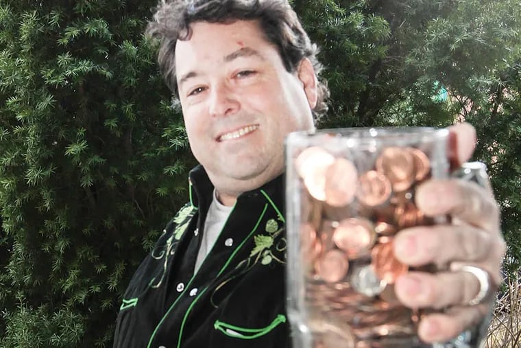 Mike "Scoats" Scotese, owner of the Grey Lodge Pub, holds a mug full of pennies; it's one of the Feats of Strength on Festivus. Wednesday,  December 10, 2014. (  Steven M. Falk / Staff Photographer )