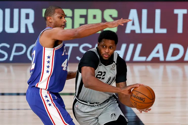 The Spurs' Rudy Gayis defended by the 76ers' Al Horford.