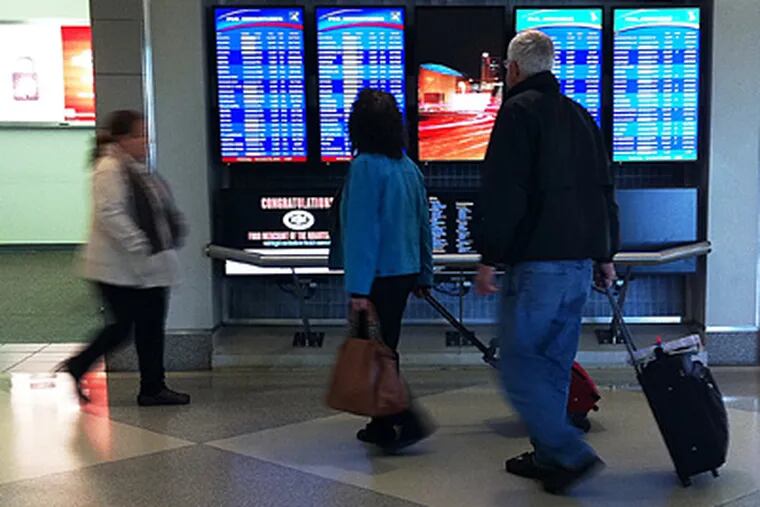 Travelers look at the Arrival and Departure board in Terminal D at Philadelphia International Airport on Wednesday, November 24, 2010. (Alejandro A. Alvarez / Staff Photographer)