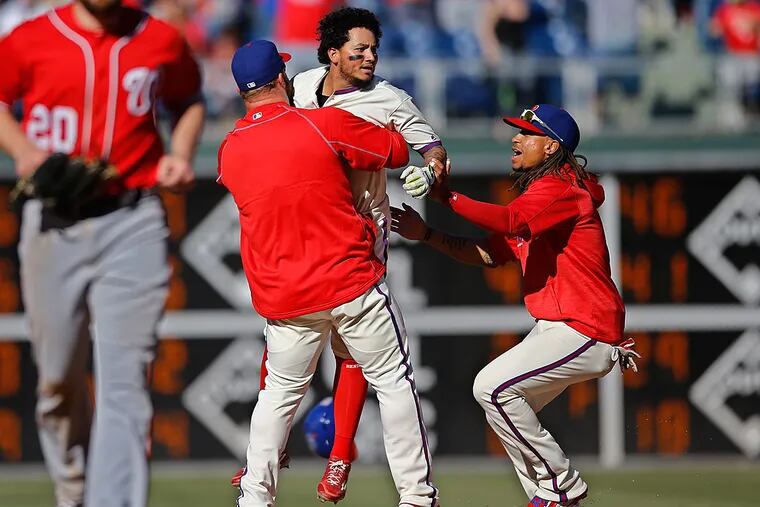 Phillies shortstop Freddy Galvis (center) is mobbed by his teammates
after hitting a walk-off double to drive in the winning run.