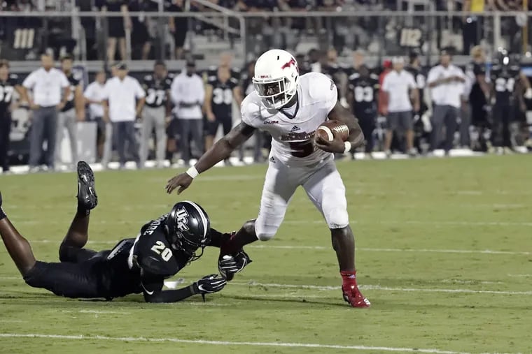 Florida Atlantic running back Devin Singletary (5) slips past Central Florida defensive back Brandon Moore (20) for a 9-yard touchdown run during the first half of an NCAA college football game, Friday, Sept. 21, 2018, in Orlando, Fla. (AP Photo/John Raoux)