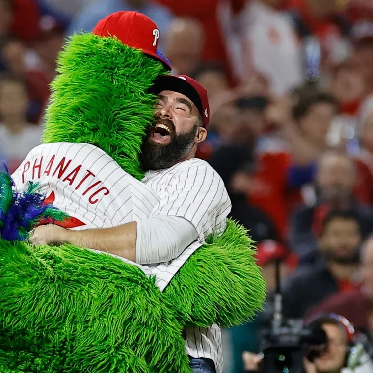 Jason Kelce jumps and hugs the Phillie Phanatic during the 2022 National League Championship Series. He'll join fellow former Eagle Fletcher Cox in throwing out the first pitch on Saturday.
