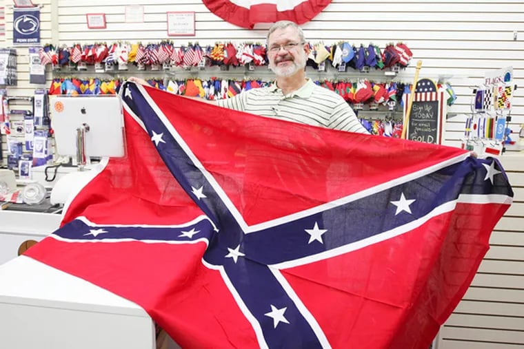 Charlie Hauber displays a Confederate flag at his Flag &Sign store in Broomall, on Wednesday, September 11, 2013. ( Steven M. Falk / Staff Photographer)