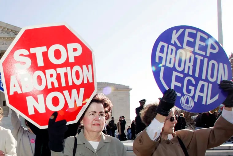 An anti-abortion supporter stands next to a  pro-choice demonstrator outside the U.S. Supreme Court in Washington in 2005. Sixteen years later, the perennial debate is back before the court -- as well as before the FDA and state legislatures.  (AP file photo)
