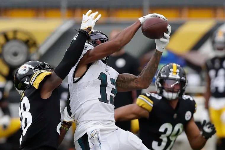 Eagles wide receiver Travis Fulgham catching the football past Pittsburgh Steelers cornerback Mike Hilton (left) and free safety Minkah Fitzpatrick during the third quarter Sunday.
