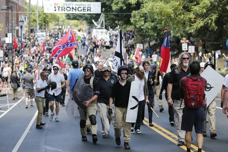 White nationalist demonstrators walk through town after their rally was declared illegal near Lee Park in Charlottesville, Va., Saturday, Aug. 12, 2017.