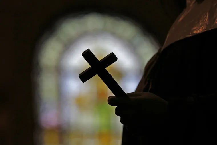 This file photo shows a silhouette of a crucifix and a stained glass window inside a Catholic Church.