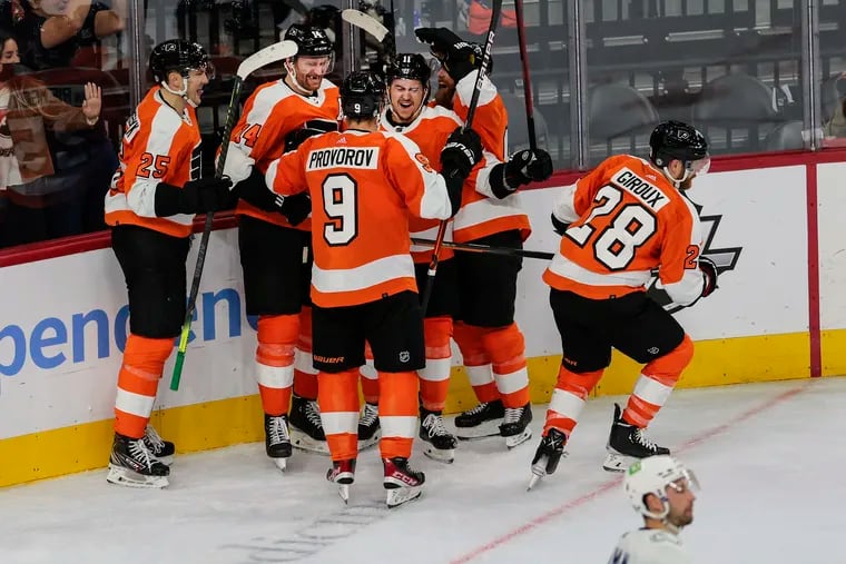Flyers captain Claude Giroux (28) celebrates with his teammates after his game-tying late in regulation Friday against Vancouver. The Flyers dropped a 5-4 shootout decision in their season opener at the Wells Fargo Center.