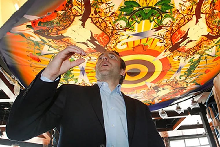 Reed Cordish, VP of The Cordish Company, walks underneath a mural in the PBR Bar and Grill. (Alejandro A. Alvarez/Staff Photographer)