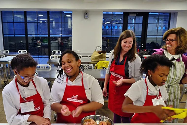 Students smile during My Daughter's Kitchen cooking class held at the Free Library of Philadelphia, Central Branch, on Monday, December 1, 2014.  (C.F. Sanchez / Staff Photographer)