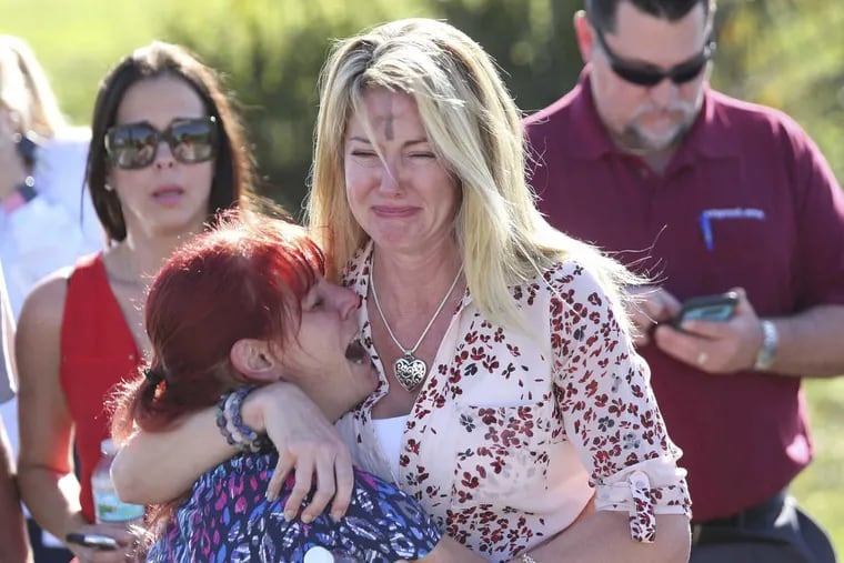 Parents wait for news after hearing about a shooting at Marjory Stoneman Douglas High School in Parkland, Fla., on Wednesday, Feb. 14, 2018.