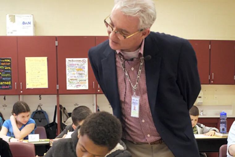 Kevin Riordan checks fifth grader Jason Califf-Wescott's work. Riordan was teacher for a day at Kilmer School in Cherry Hill. (Tom Gralish / Staff Photographer)