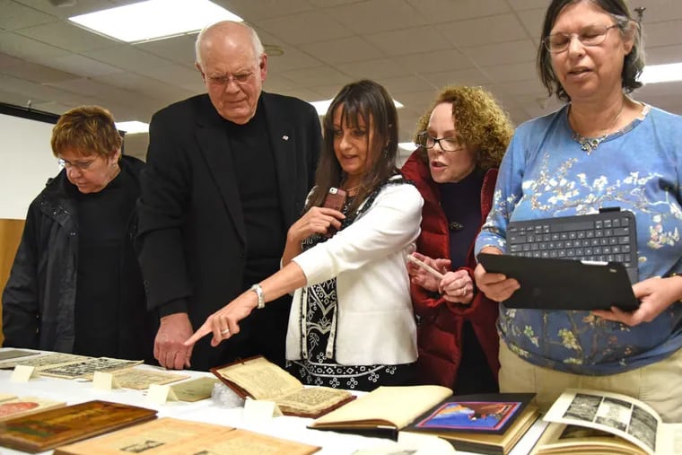Dr. Ierachmiel “Yerach” Daskal (second from left), of Elkins Park, talks with attendees at his lecture and opening of an exhibit of Daskal&#039;s collection of historic Haggadot at Gratz College. Haggadot are the books used during a Passover seder to guide those gathered through the holiday meal.
