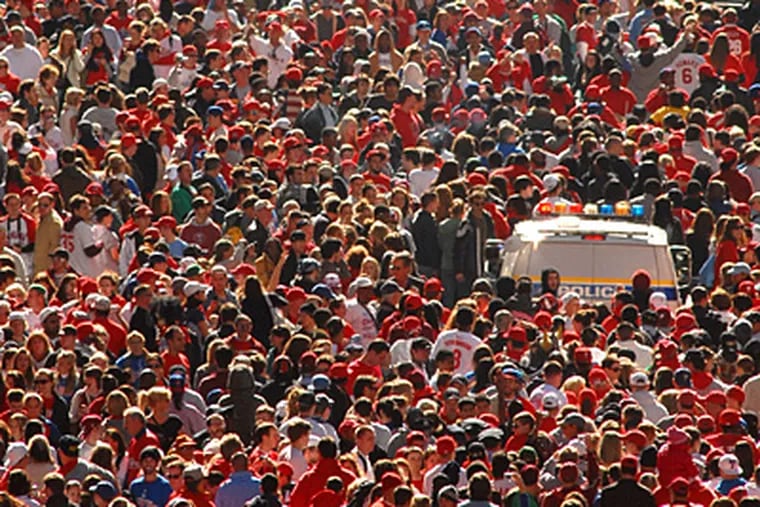 Phillies parade on S. Broad as police van tries to move through. (Peter Tobia / Staff Photographer)