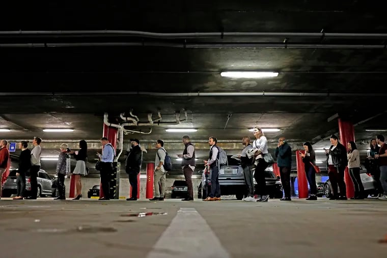 In this Tuesday, Nov. 6, 2018, file photo, a line backs up into a parking garage outside a polling site on Election Day in Atlanta. In Georgia, where claims of voter suppression in the state’s 2018 governor’s race is the basis of a federal lawsuit, Republicans have passed measures relaxing some restrictions and requiring more notification before voters are removed from registration lists.