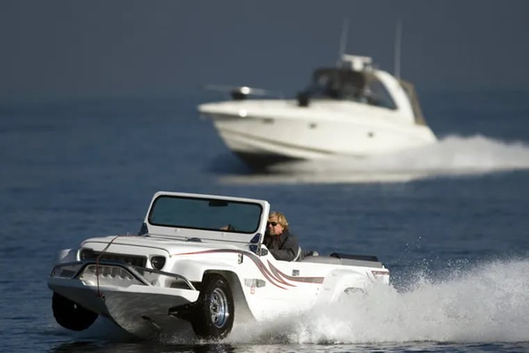 Dave Marsh is flanked by his son Mike's boat during a test drive in his WaterCar to Catalina Island, Jan. 13, 2014. (Kevin Sullivan/Orange County Register/MCT)