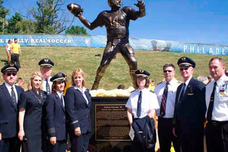 United and Continental Airlines pilots and crew, all friends of Mike Horrocks', stand by his statue at Farrell Stadium. (Ed Hille / Staff Photographer)