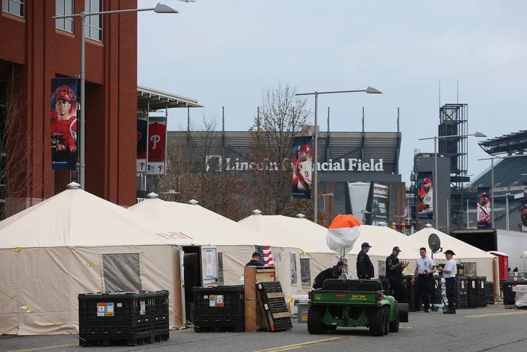 Pennsylvania Task Force 1 members stand near tents after the city's coronavirus testing site opened next to Citizens Bank Park on March 20.