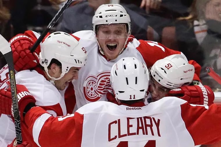 Red Wings center Gustav Nyquist, top, celebates his winning goal with Jonathan Ericsson, left, Daniel Cleary (11) and Valtteri Filppula. 
(Chris Carlson / AP)
