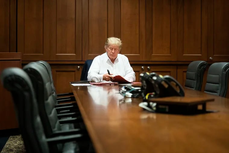 In this image released by the White House, President Donald Trump works in his conference room at Walter Reed National Military Medical Center in Bethesda, Md., Saturday, Oct. 3, 2020, after testing positive for COVID-19.